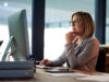 Woman at the PC sets up the onOffice showcase TV