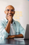 Smiling man sitting in front of laptop