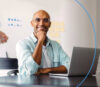 Smiling man sitting in front of laptop