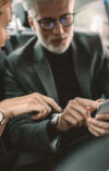 2 people in the car use the onOffice broker app on their smartphone.